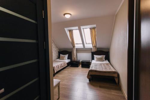 a small room with two beds and a window at Biдень in Lviv