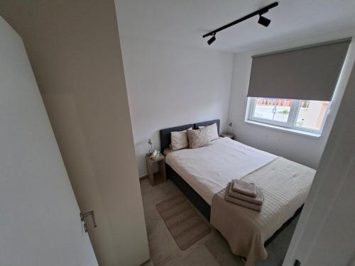 ein kleines Schlafzimmer mit einem Bett und einem Fenster in der Unterkunft Silver 1 & SPA in Veliko Gradište