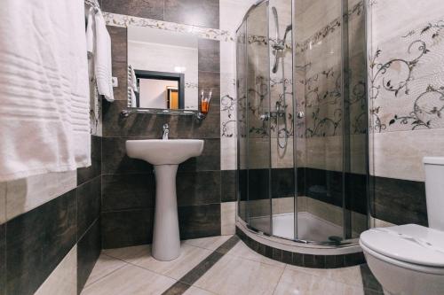 a bathroom with a sink and a shower and a toilet at Biдень in Lviv