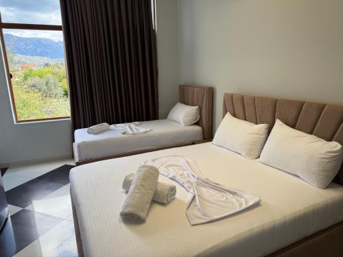 two beds in a hotel room with towels on them at OLI Hotel in Fushë-Krujë