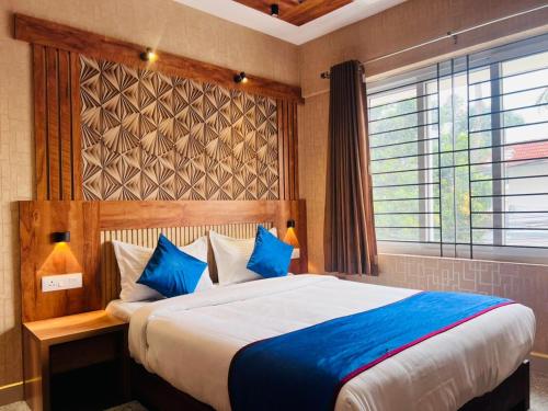 a bedroom with a large bed with blue pillows at Celestial Heights Kakkanad in Cochin