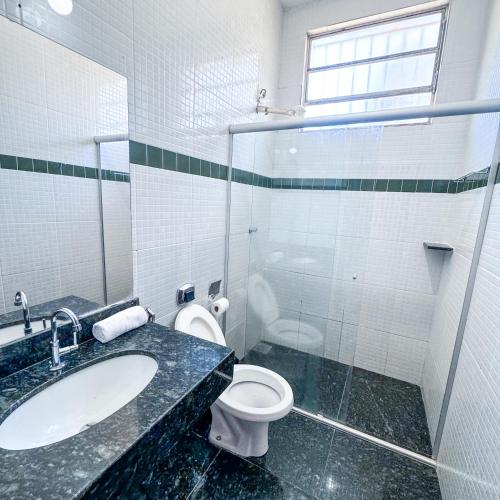a bathroom with a toilet and a sink and a mirror at Pousada Grande Rio in Pirapora