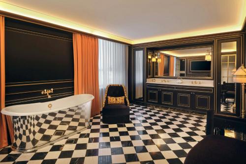 a bathroom with a tub and a checkered floor at L'Escape, a Luxury Collection Hotel, Seoul Myeongdong in Seoul