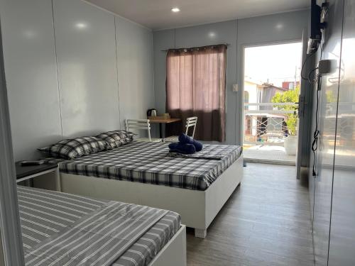 a bedroom with two beds and a window with a view at A Residences in San Fernando