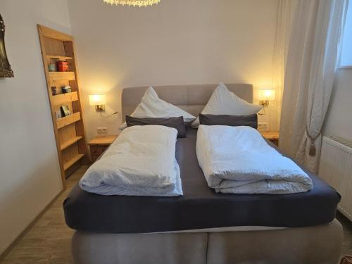 a bed with two pillows on it in a room at Ferienwohnung Christine in Bischofswiesen