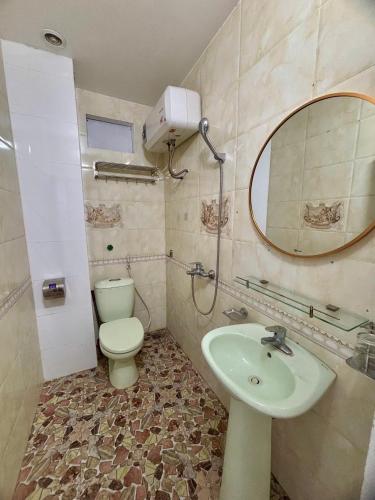 a bathroom with a toilet and a sink and a mirror at Pá Homestay - Thành phố Cao Bằng in Cao Bằng