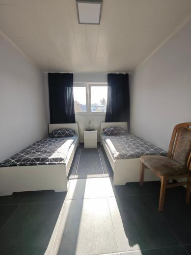 a room with two beds and a chair in it at Zimmervermietung-Nbg in Nuremberg
