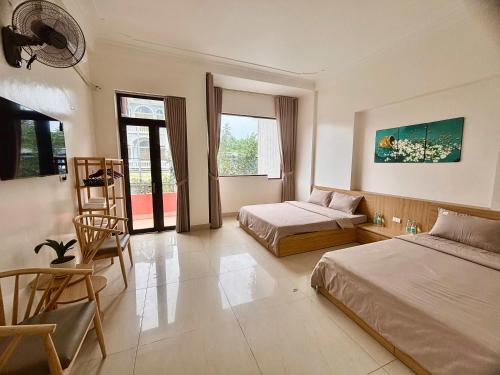 a bedroom with two beds and a chair in it at Pá Homestay - Thành phố Cao Bằng in Cao Bằng