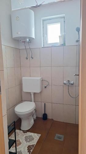 a bathroom with a white toilet and a window at GREEN MOON Breza in Breza