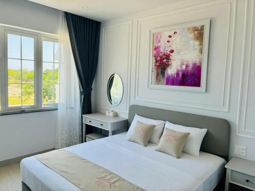 a white bedroom with a bed with two pillows at Happy House in Cam Lâm
