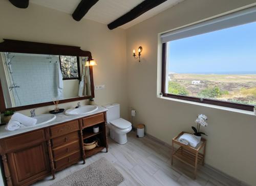 a bathroom with a sink and a toilet and a window at Casona de Tao in Tiagua
