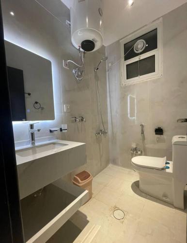 a bathroom with a sink and a shower and a toilet at شقق نور الفخامه المخدومه in Buraydah