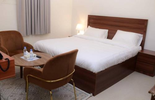 a hotel room with a bed and a table and chairs at شقق نور الفخامه المخدومه in Buraydah