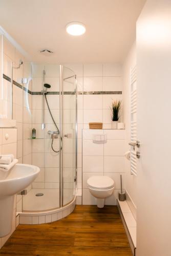 a bathroom with a shower and a toilet and a sink at Restaurant & Pension Skipper Zingst in Zingst