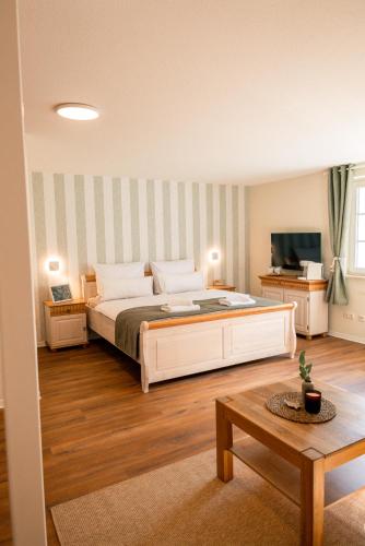 a bedroom with a large bed and a television at Restaurant & Pension Skipper Zingst in Zingst