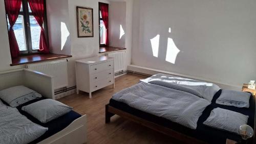 a bedroom with two beds and a dresser and windows at HabaChalupa in Šumperk
