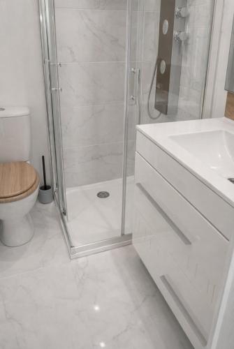 a white bathroom with a shower and a toilet at Le Cocon du Ventoux Studio cosy à Carpentras in Carpentras