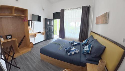 a bedroom with a bed with blue pillows on it at Adroit Sunset View in Guraidhoo