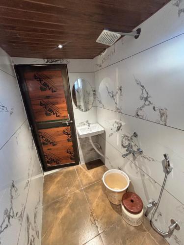 a bathroom with a toilet and a sink at Hotel Shree Balaji in Ujjain