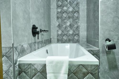 a white bath tub in a bathroom with a towel at Lifestyle Boutique Hotel in Lilongwe