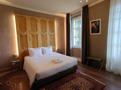 a bedroom with a large white bed with a window at Capriccio Art Hotel in Serravalle Scrivia