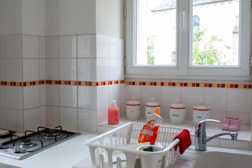 a kitchen counter with a sink and a stove at Le Petit Marigny in Marigny-lʼÉglise