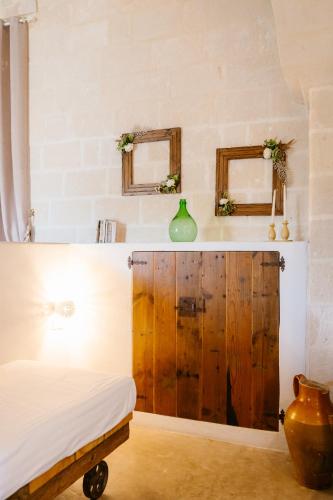 a bedroom with a bed and two mirrors on the wall at Tenuta del Barco WineRestaurant and Hospitality in Pulsano