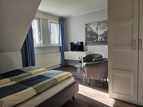 a bedroom with a bed and a desk and a chair at Moderne Ferienwohnung "Adriane" mit gehobener Ausstattung - Top bewertet in Nordhorn
