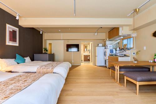 a hotel room with two beds and a kitchen at Tokyo Base Meguro in Tokyo