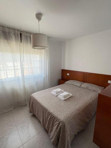 a bedroom with a bed with two towels on it at Alojamiento caral in Laxe