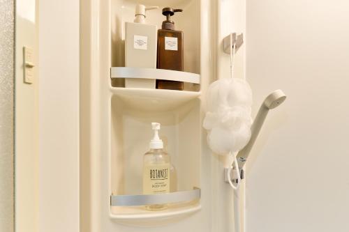 a refrigerator door with bottles of soap andodorizers in it at Tokyo Base Meguro in Tokyo