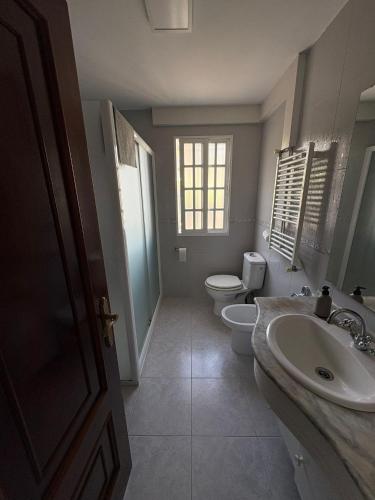 a bathroom with a toilet and a sink and a toilet istg at Alojamiento caral in Laxe
