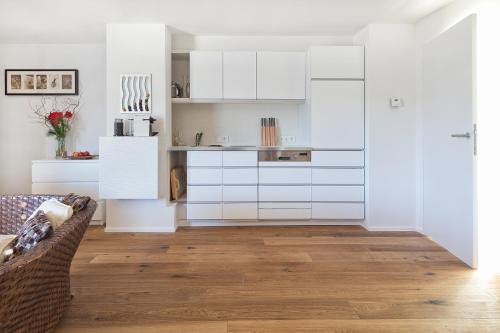 eine Küche mit weißen Schränken und Massivholzböden in der Unterkunft Lakeview Studio in St. Wolfgang