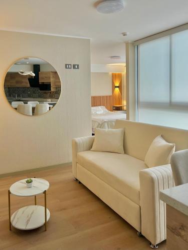 a living room with a couch and a mirror at Condo Apartment Suite Misti Volcano View in Arequipa