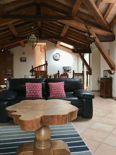 a living room with a black couch and a wooden table at Toulouse in Bazus