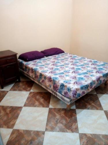 a bed sitting on a floor in a room at Location près de la plage in Tichi