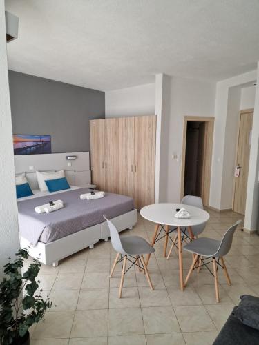 a bedroom with a bed and a table and chairs at BLUE EYES APARTMENTS in Ixia