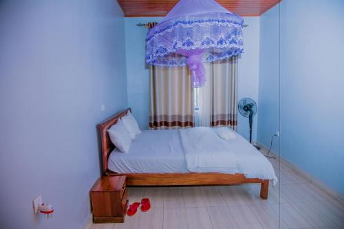a bedroom with a bed with a canopy and a window at Ritha Motel Apartment in Kigali