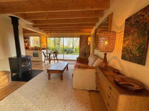a living room with a couch and a stove at Chalet Cormoran, face à l'océan in Fouesnant