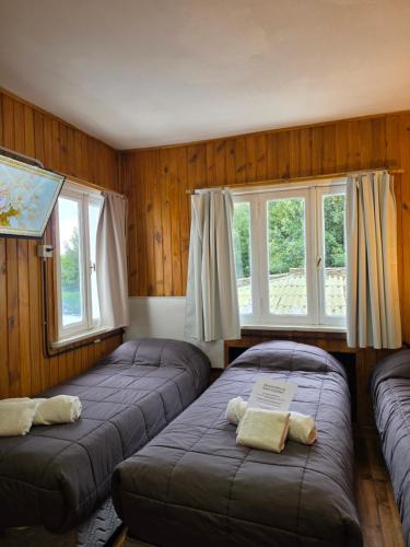 two beds in a room with two windows at Hotel Surprise Bariloche Centro con Desayuno y Restaurante in San Carlos de Bariloche