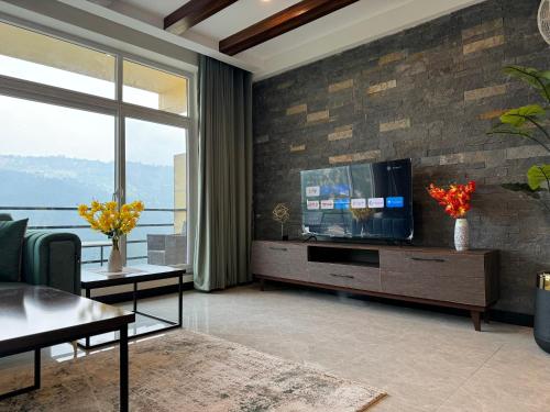 a living room with a flat screen tv on a brick wall at Murree Spring Apartment in Murree