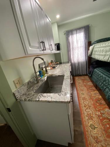 a kitchen with a sink in a room with a bed at Must See Okemo Mountain Resort in Springfield