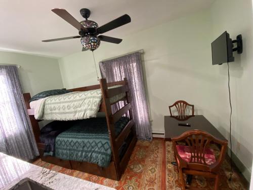 a bedroom with a bed and a ceiling fan at Must See Okemo Mountain Resort in Springfield