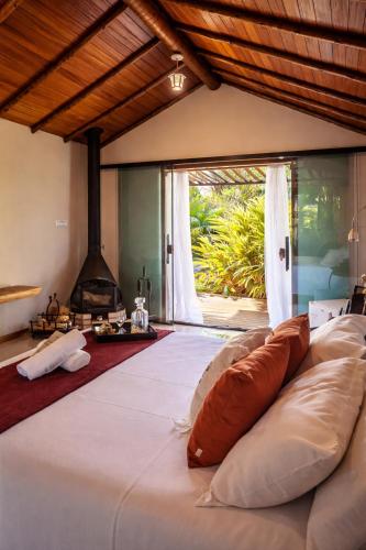 a bed with pillows in a room with a fireplace at Villa Sana Maritacas in Sana