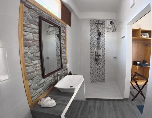 a bathroom with a sink and a shower with a mirror at Adroit Sunset View in Guraidhoo