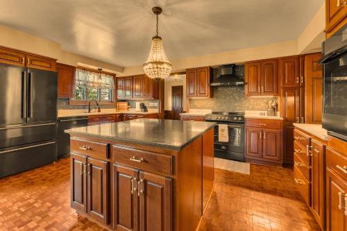 a large kitchen with wooden cabinets and a chandelier at The John Collins House in Canfield