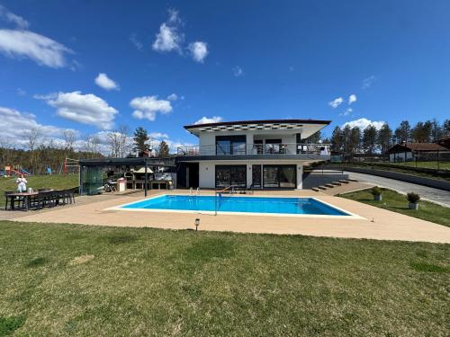 a large house with a swimming pool in front of it at Luxury Villa Rafaela Οικογενειακή βίλα με ιδιωτική πισίνα, BBQ κ παιχνίδια Ιδανική για οικογένειες με παιδια in Grevena
