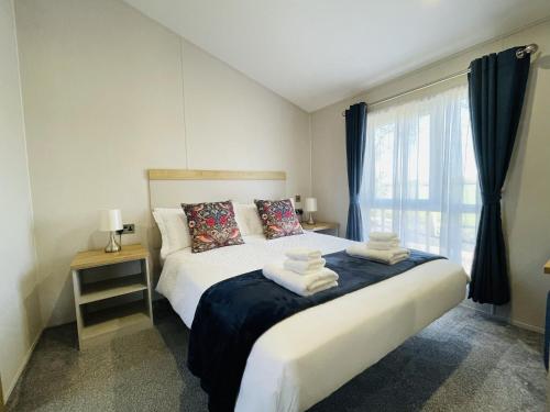 a bedroom with a bed with towels on it at Fleece Lodge in Bledington