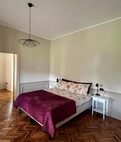 a bedroom with a large bed with a purple blanket at Casa Amrita B&B in Teramo