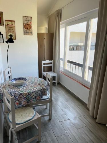 a dining room with a table and a window at Óasis - Pedras D' El Rei T0 in Santa Luzia